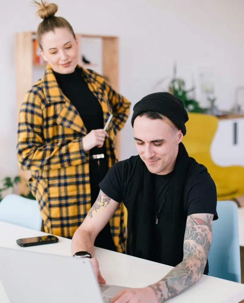 Woman Watching While Man Works On A Laptop